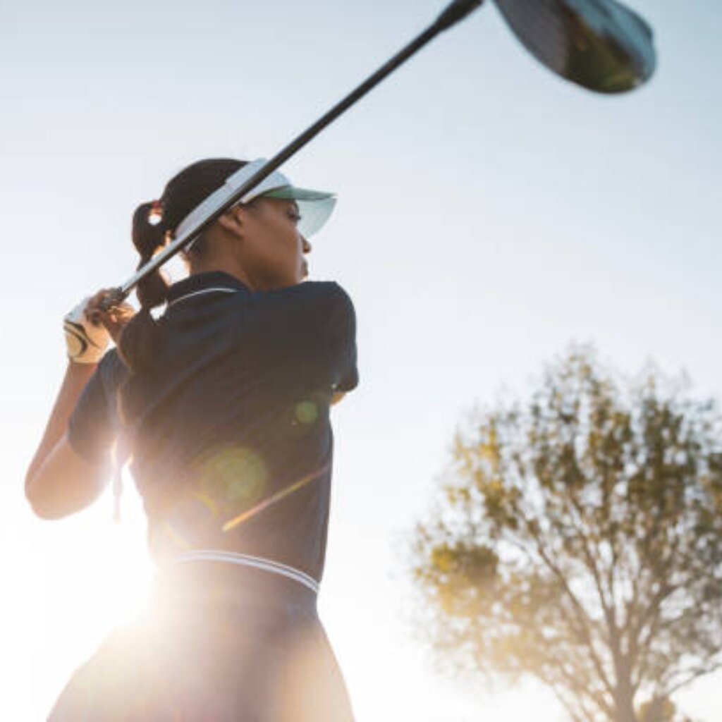 Golfer at the top of the backswing against a bright sky